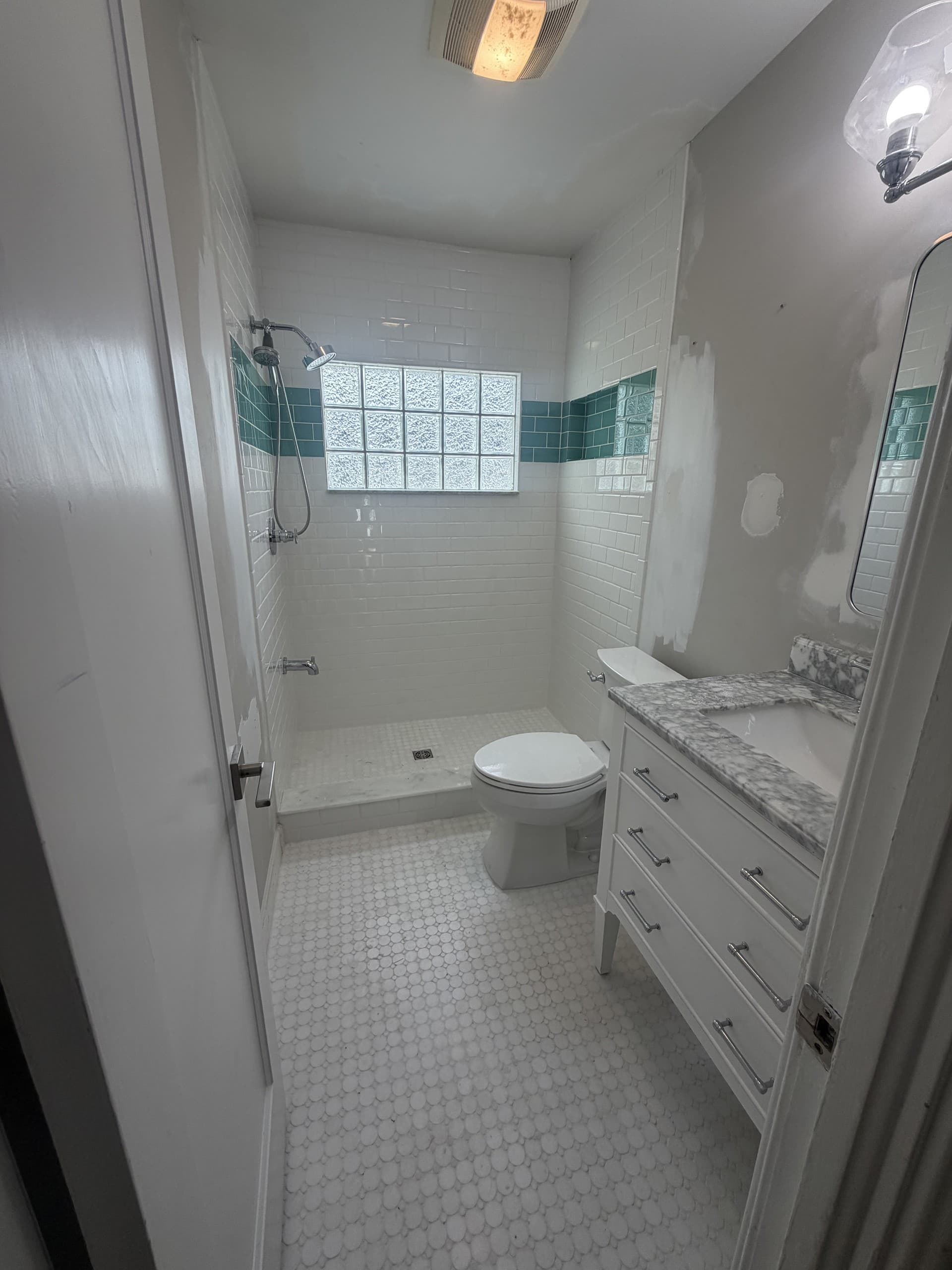 Finished Karhan bathroom — subway tile shower with a teal glass accent band, College Park, Orlando