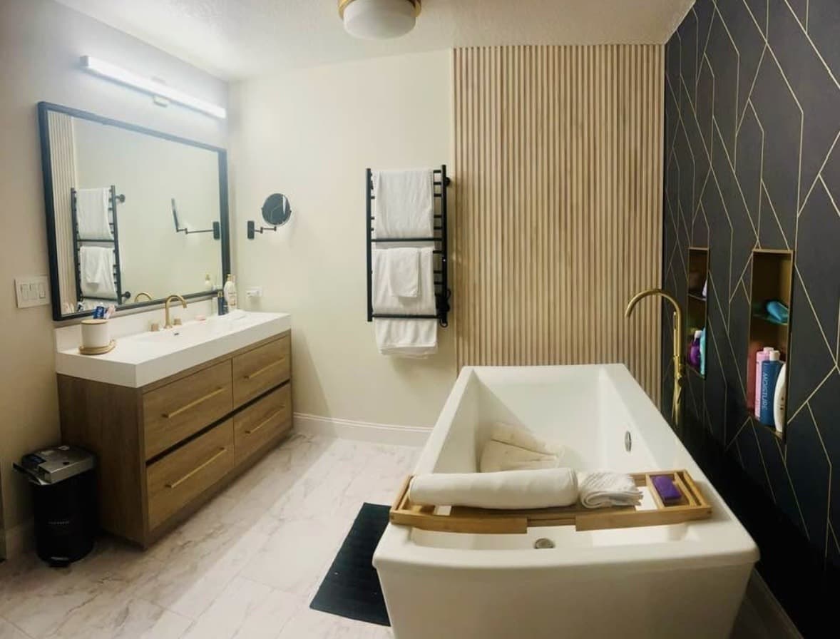 Real Karhan master-bath remodel — freestanding tub, wood-slat & dark hex feature walls, Orlando area