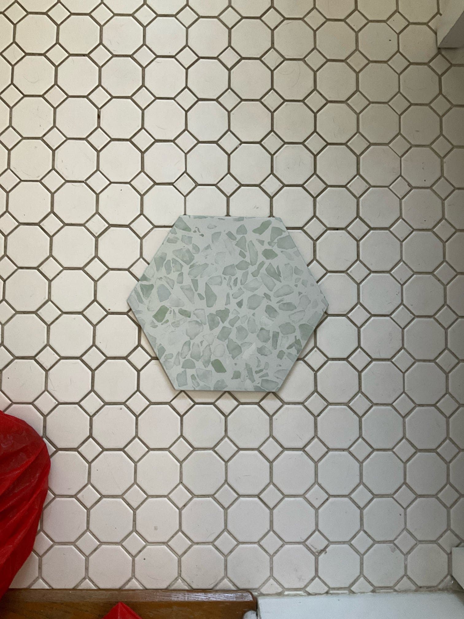 BEFORE — tile sample laid on the original floor during design selection (real Karhan project)