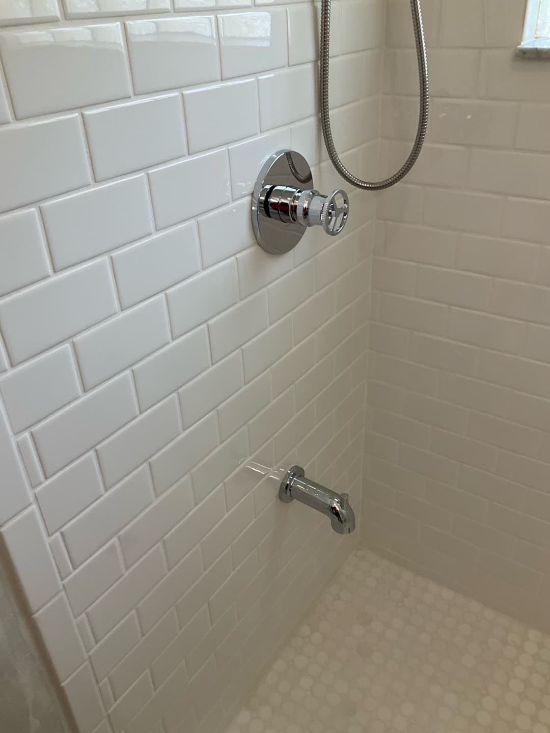 AFTER — finished shower fixtures against white subway tile with a teal glass accent band (real Karhan project, College Park)