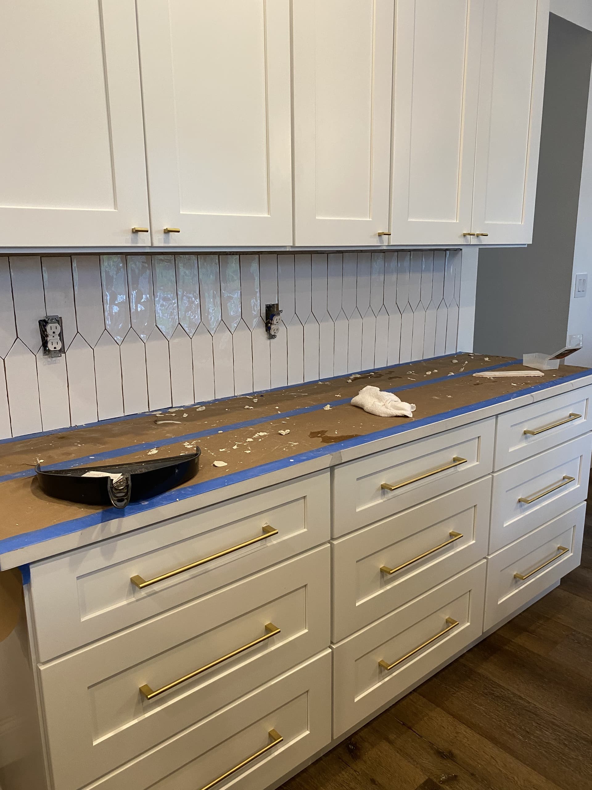 DURING — decorative picket backsplash tile mid-installation (real Karhan project)