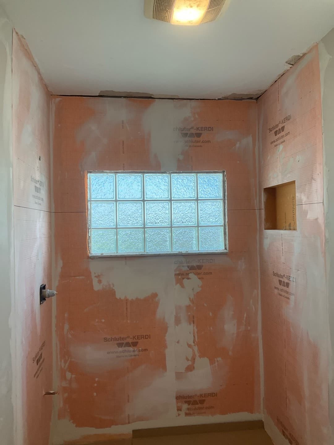Schluter-Kerdi waterproofing membrane installed across the shower walls and window surround (real Karhan project)